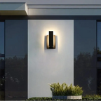 Luminaire mural extérieur aluminium noir design moderne, fixé sur un mur blanc lumineux.