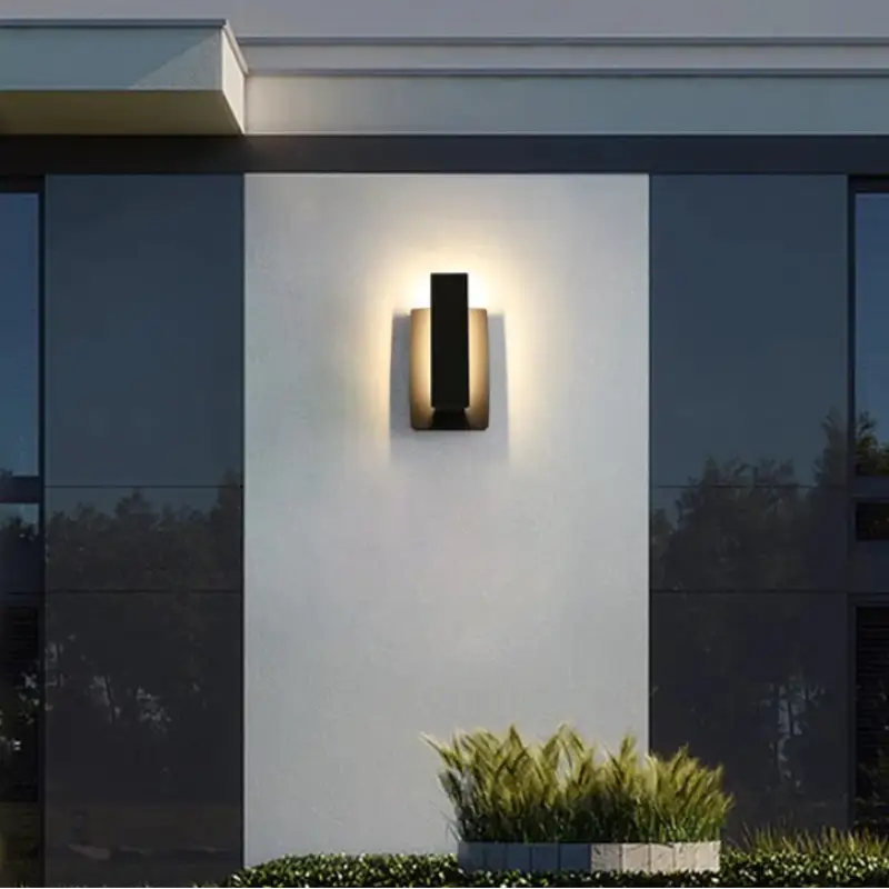 Luminaire mural extérieur aluminium noir design moderne, fixé sur un mur blanc lumineux.
