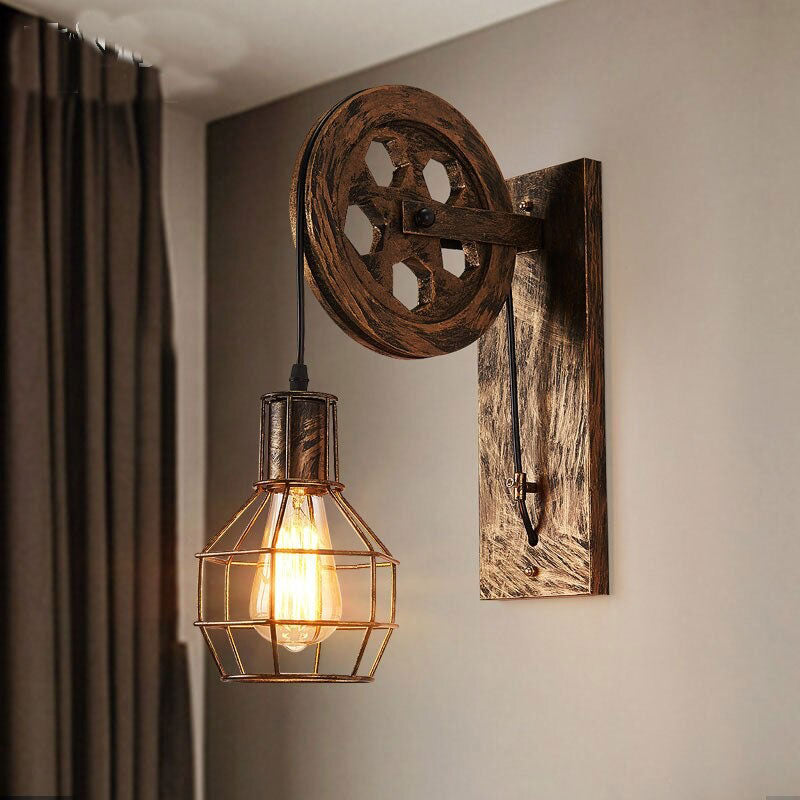 Industrial wall light casts warm Edison glow with rustic wooden pulley and metal cage.