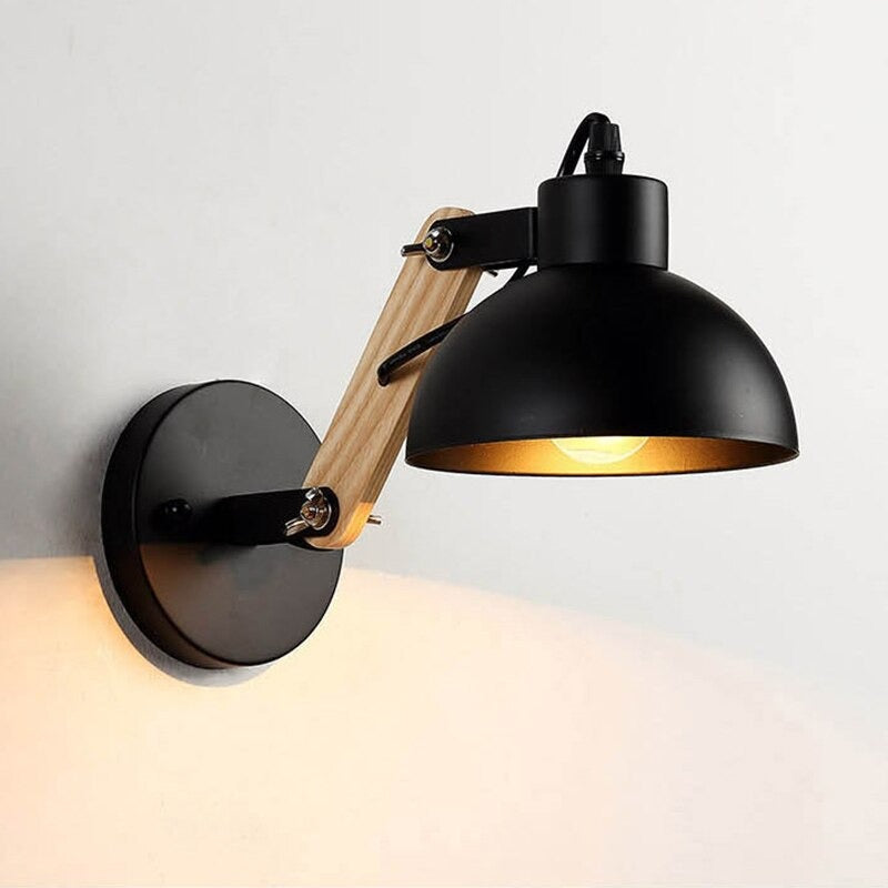 Warm glow shines from a black metal shade and adjustable wooden-arm wall light.