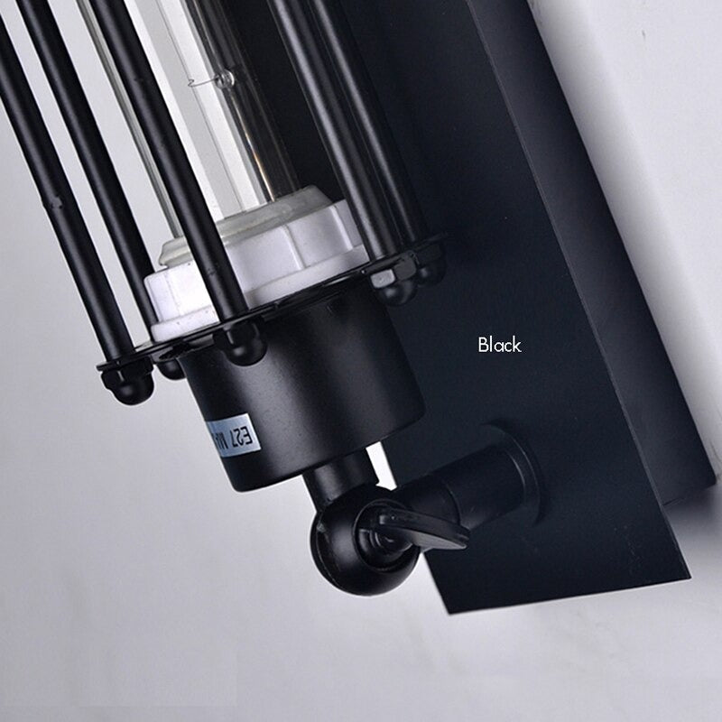 Black iron sconce casts focused, moody light with tubular protection and retro industrial flair.