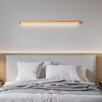 The ORLUNE HOME LED Wall Light casts a warm, inviting glow in the minimalist room.