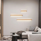Three ORLUNE HOME adjustable LED wooden wall lights bring modern warmth to white walls.