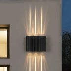 Applique murale LED aluminium ondulé diffusant une lumière douce aux motifs verticaux élégants.