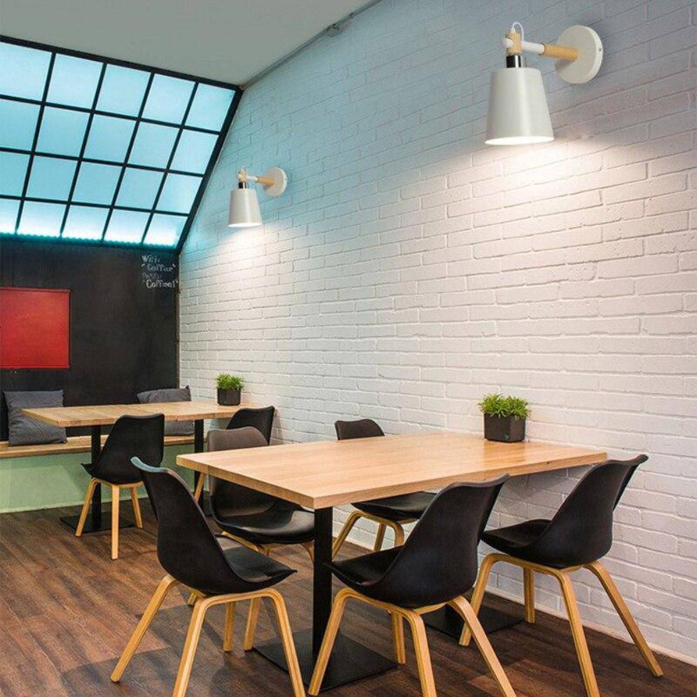 Bright natural light streams through a geometric window, enhanced by Nordic Modern wall lamps.