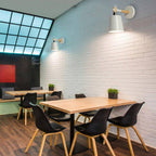 Bright natural light streams through a geometric window, enhanced by Nordic Modern wall lamps.