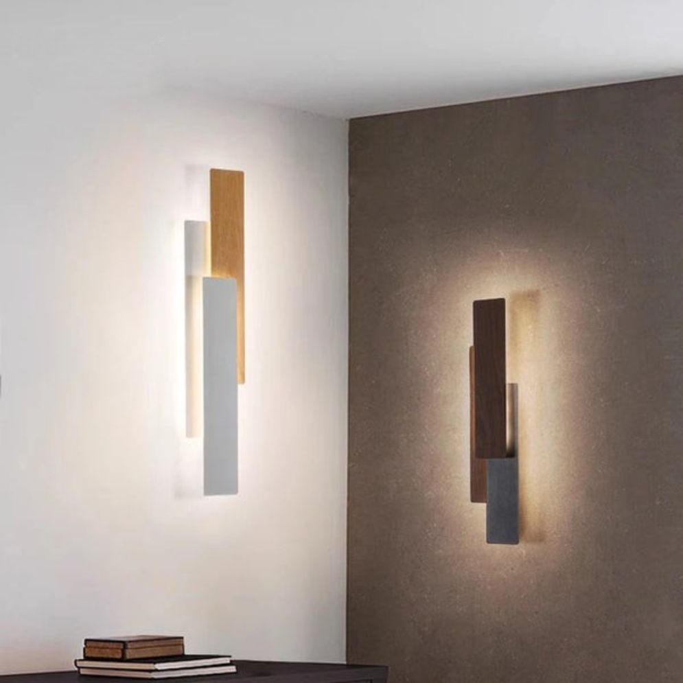 Rectangular wooden LED wall lights with overlapping panels cast a warm, dimmable glow.