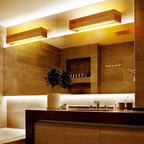 Warm yellow lighting from a Japanese LED wall light softly illuminates the bathroom.