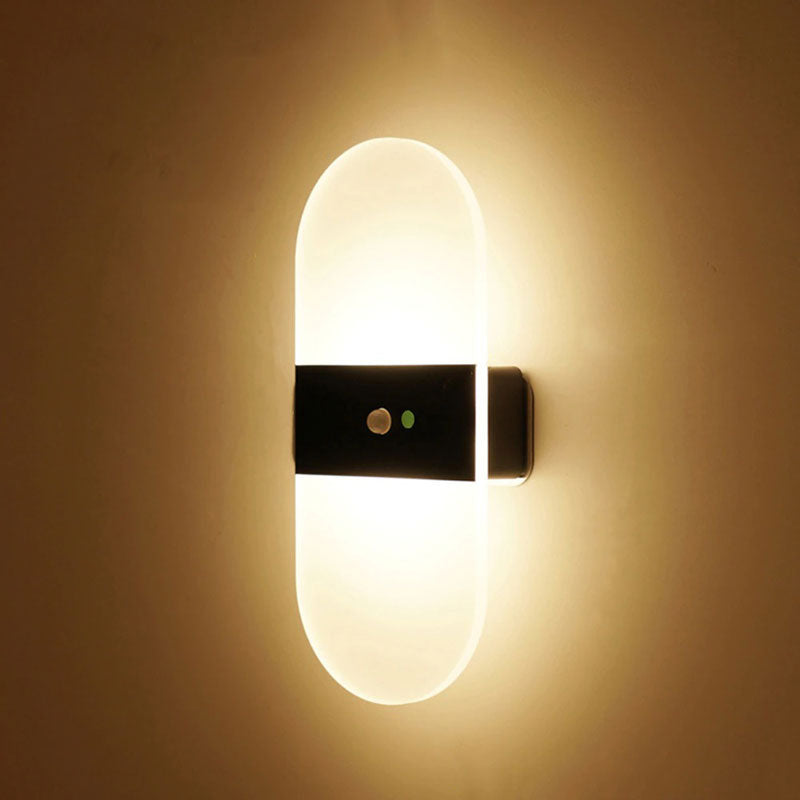 Sleek LED wall light glows warmly with transparent design and two extra indicator lights.