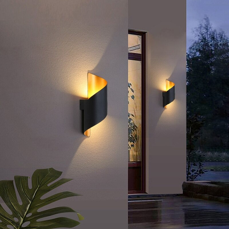 Warm spiral LED sconce glows at dusk, creating an inviting and cozy outdoor ambiance.