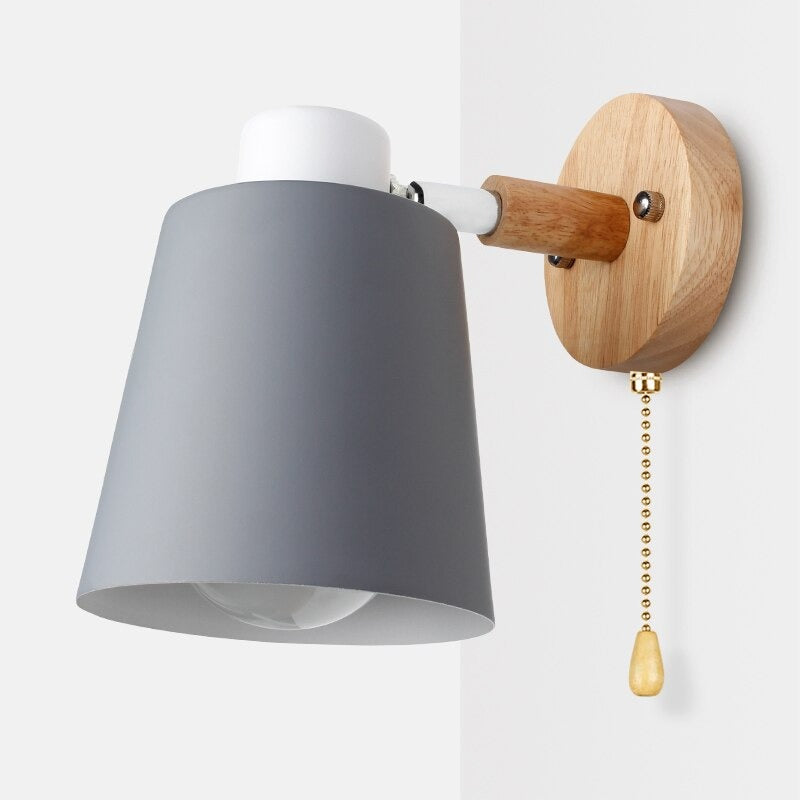Sleek wall lamp offers elegant, modern lighting with gray shade and gold pull chain.