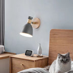 Soft, adjustable Scandinavian wood wall light casts a warm, tranquil glow above the nightstand.
