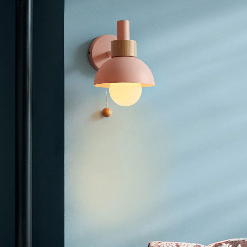 Warm lighting from a spherical bulb shines elegantly with a modern pink wall fixture.