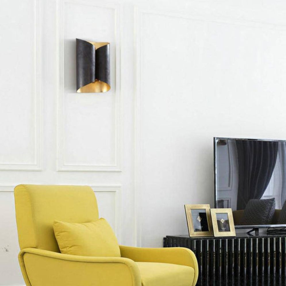 Industrial black metal wall light with curved tubes adds modern flair to white walls.