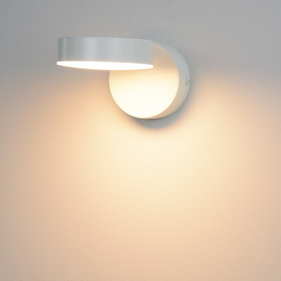 Soft, circular LED glow with adjustable head enhances minimalist lighting ambiance.