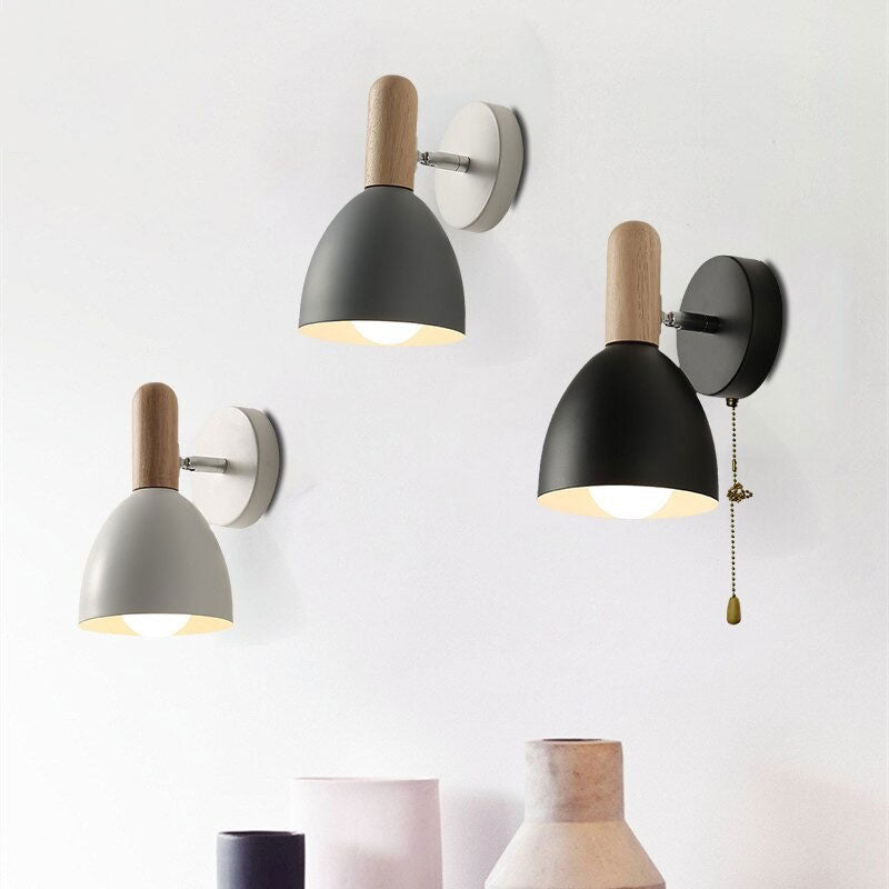 Three stylish Scandinavian bedside wall lights with dome shades glow against a clean backdrop.