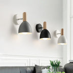 Three Scandinavian-style wall lights emit a soft, cozy glow from gray, black, and white domes.