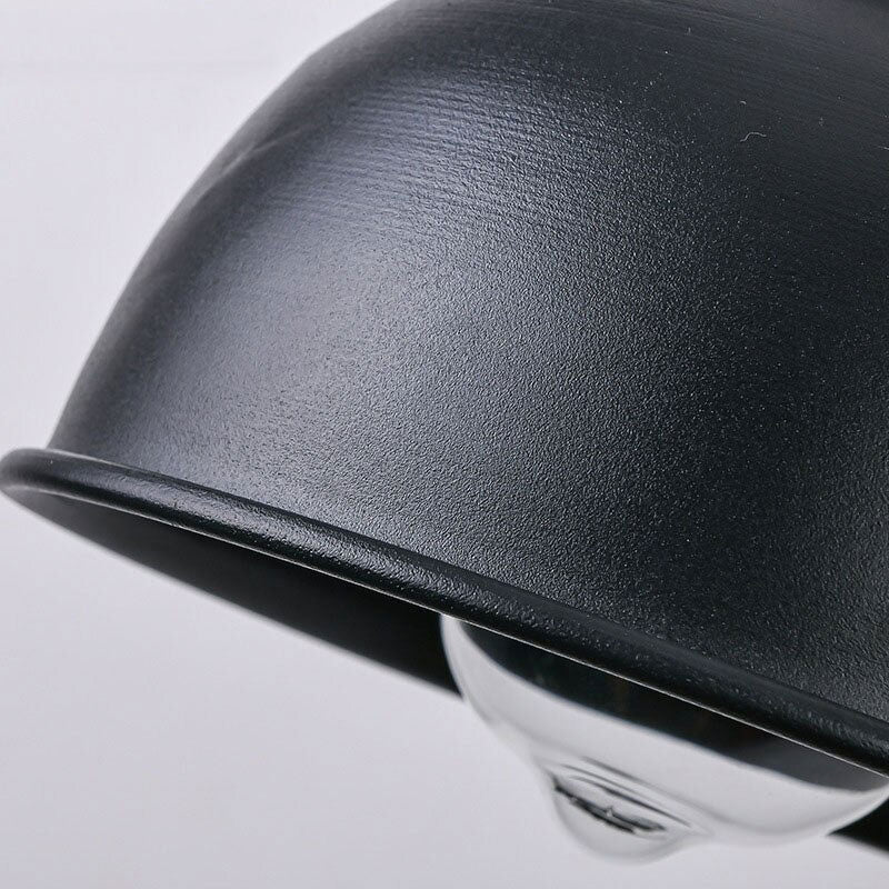Black industrial metal wall light with exposed bulb delivers focused, retro-inspired illumination.