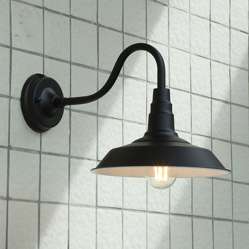 This black metal wall light with exposed bulb elevates your space’s industrial vintage lighting.