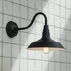 This black metal wall light with exposed bulb elevates your space’s industrial vintage lighting.