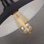 This industrial wall light casts a warm glow with an exposed filament bulb.