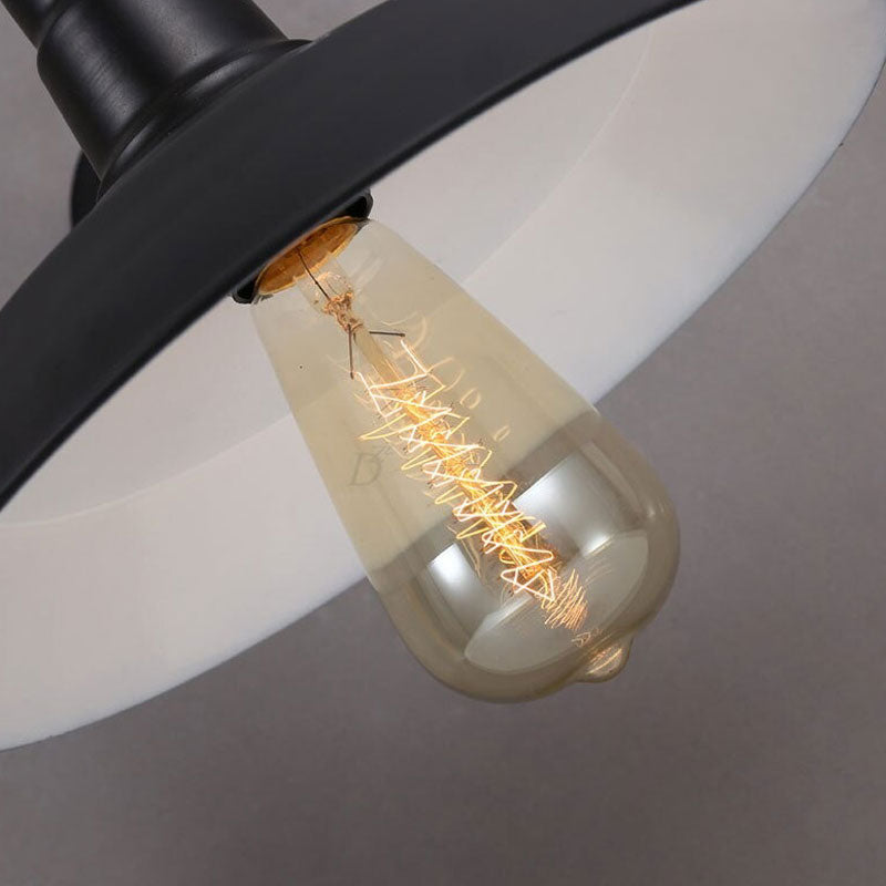 This industrial wall light casts a warm glow with an exposed filament bulb.