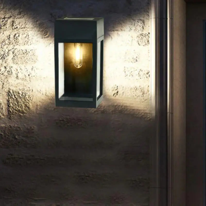 Applique murale LED solaire noire diffuse une lumière chaude et des ombres douces.