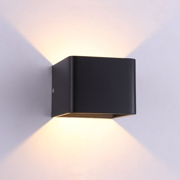 ORLUNE HOME LED wall light glows warmly, casting striking X-shaped patterns above and below.