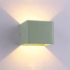 Soft green cube LED emits warm, bi-directional beams casting artistic light patterns.
