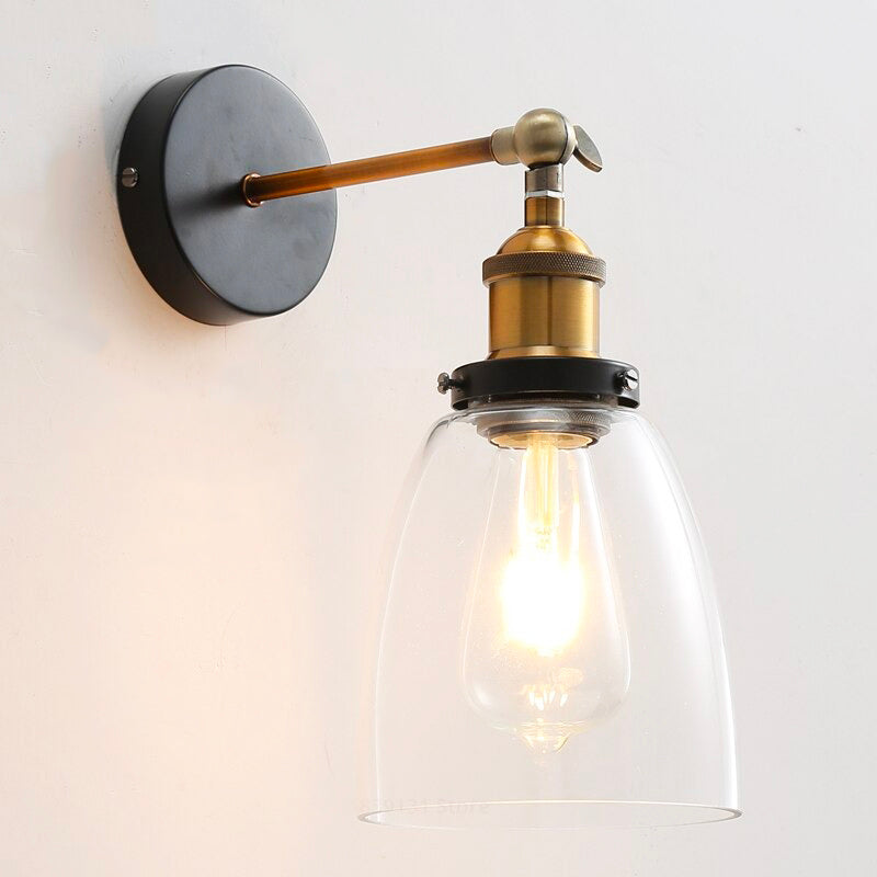 This industrial wall light casts a warm, inviting glow through its clear glass shade.
