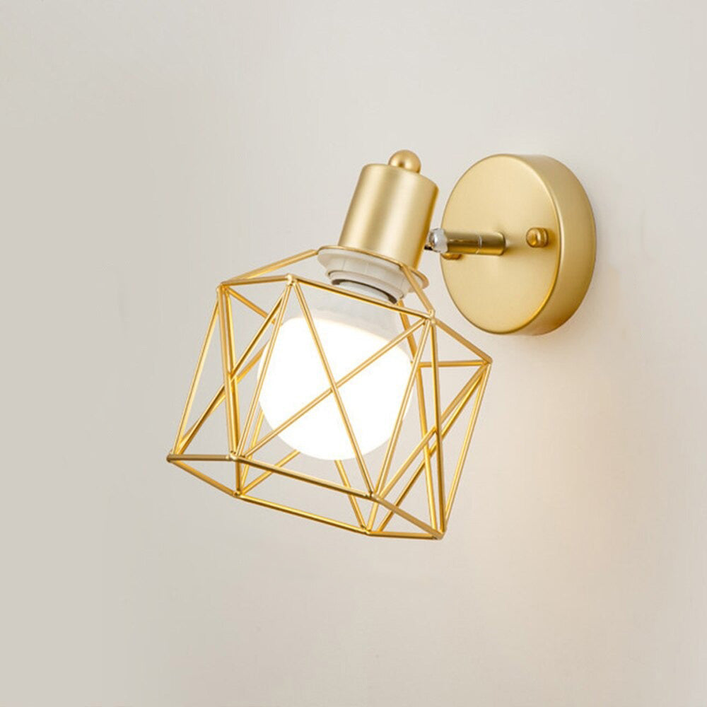 Gold geometric wire sconce offers elegant, warm illumination with a glowing white bulb.