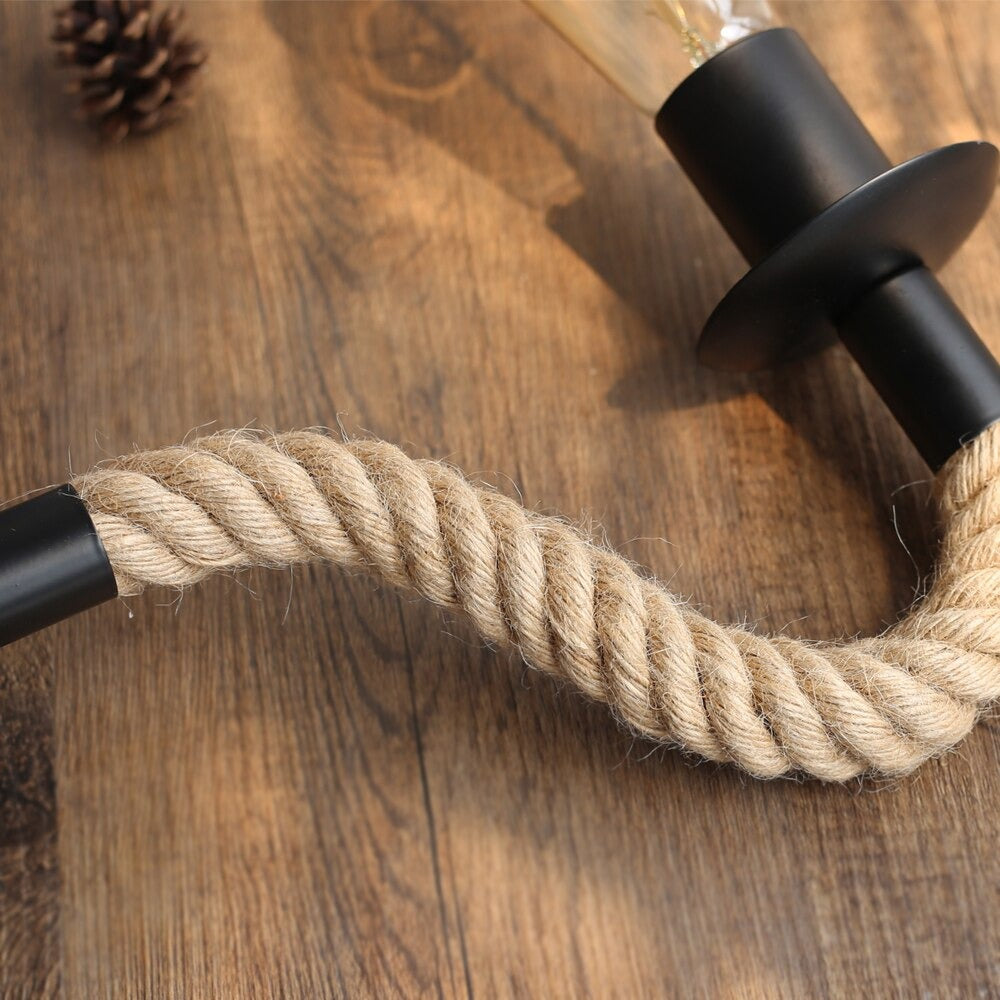 Warm, industrial-inspired lighting with a coiled beige rope and sleek black metal fixture.