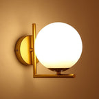 Gold metal fixture and frosted white glass shade provide a warm, modern lighting accent.