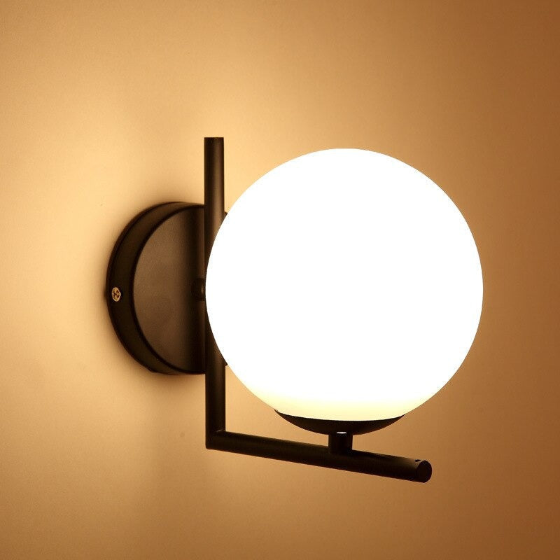 Experience soft, modern illumination from a frosted glass globe on a sleek black bracket.