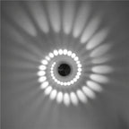 Soft LED spiral light creates radiant oval patterns and gentle circular glows on white ceilings.