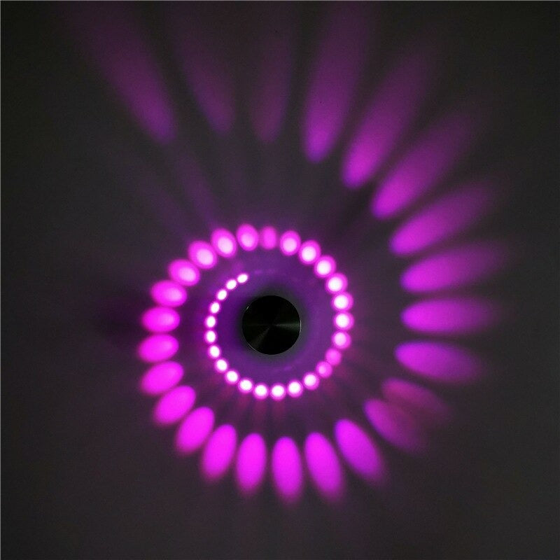 Vibrant purple spiral LED light creates glowing dots and ovals on dark surfaces.