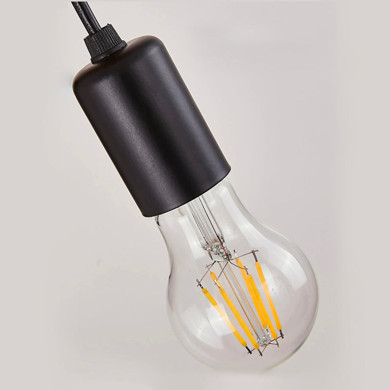 Warm yellow filaments glow inside a modern black wall sconce, casting elegant angled light.