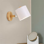 The wooden wall lamp's adjustable metal shade offers stylish, targeted Scandinavian-inspired lighting.