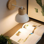 Soft retro Nordic lighting from the wall lamp creates a warm, inviting reading glow.