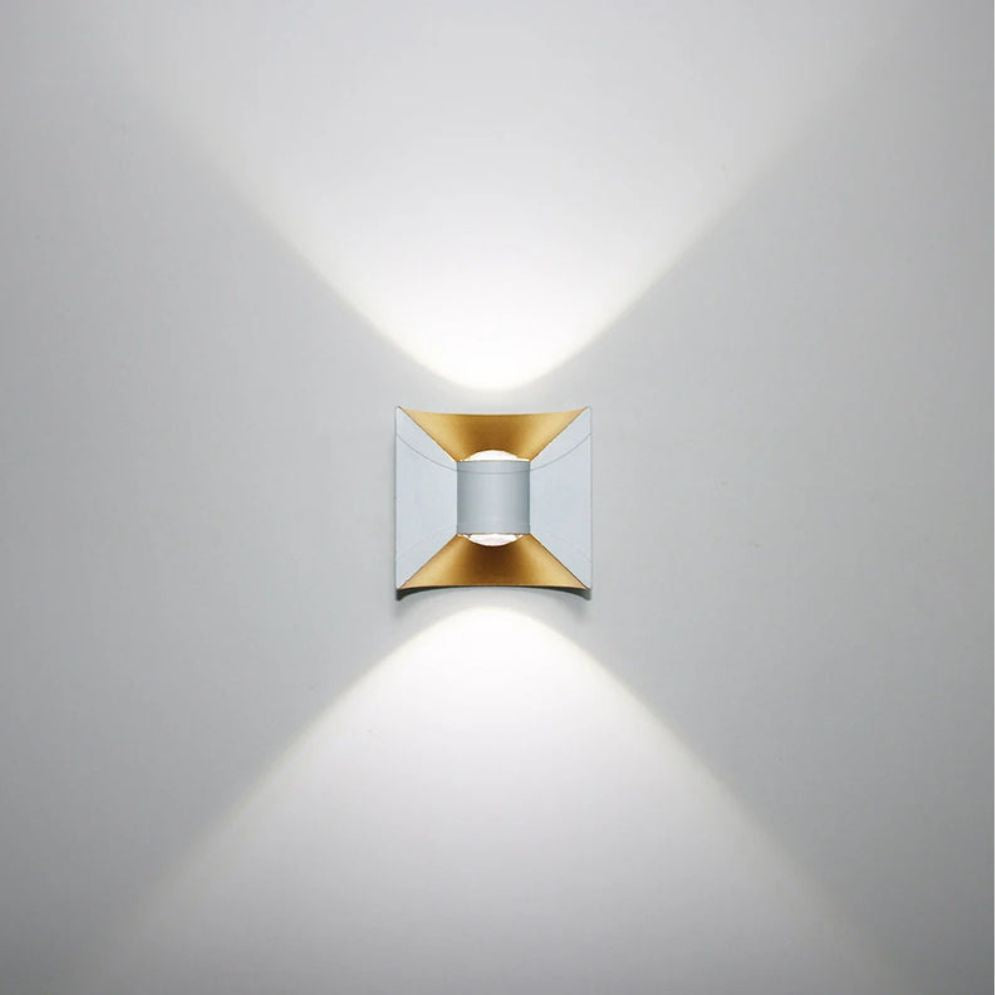 Casts dramatic X-shaped beams of gold and silver light vertically on white walls.