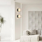 Two ORLUNE HOME glass aluminum wall sconces add chic, modern lighting to the space.