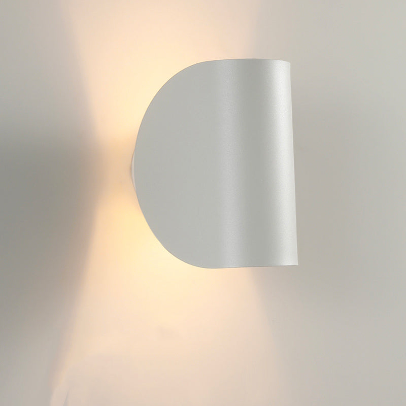 Luminaire mural LED moderne en métal, forme courbée, lumière douce et chaleureuse.