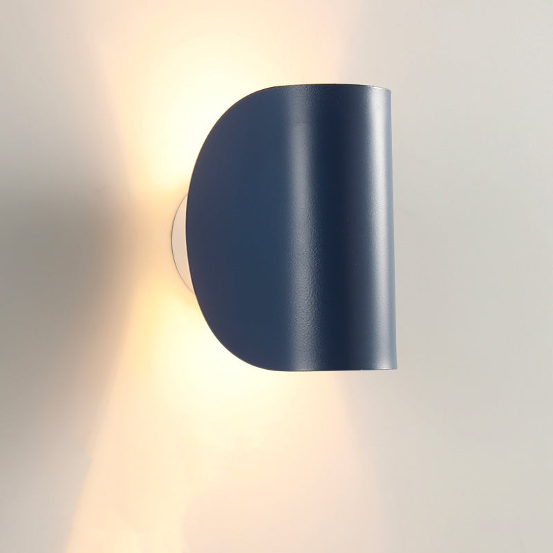 Luminaire mural noir mat courbé diffuse une lumière LED chaude vers le haut et le bas.