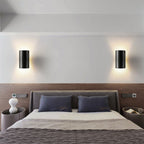 Deux appliques murales LED modernes en métal, design LUMINAIRE MAISON, éclairent au-dessus du lit.