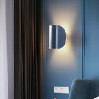 Applique murale LED en métal noir courbé, lumière chaude, design moderne pour salle de bain.