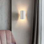 Applique murale LED moderne en métal, éclaire doucement le mur d'une lumière chaude.