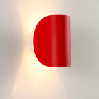 Luminaire mural rouge en métal courbé, LED intégrée, diffuse une lumière chaude motif unique.