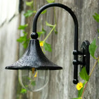 La LUMINAIRE MAISON Applique murale extérieur rétro en métal noir avec gouttelettes sur l'abat-jour.