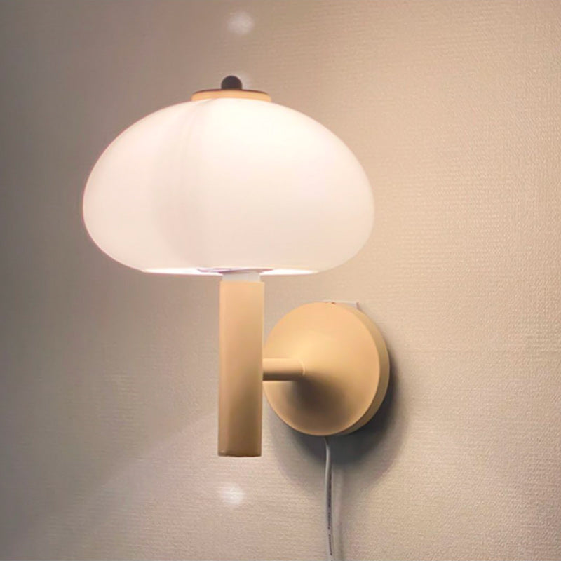 Soft, frosted glass glows warmly; visible cord adds character to this stylish mushroom wall light.