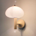 Soft, frosted glass glows warmly; visible cord adds character to this stylish mushroom wall light.
